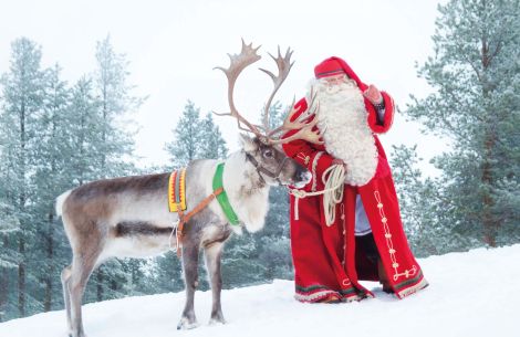 Santa Claus mit Renntier im Schnee